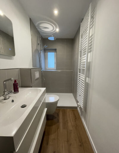 Ein von der Kronen Immobilien GmbH Velbert aufbereitetes kleines Badezimmer mit Holzboden für ein Fix und Flip Projekt